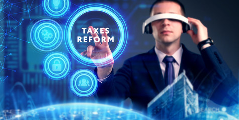 Business, Technology, Internet and network concept. Young businessman working on a virtual screen of the future and sees the inscription: taxes reform