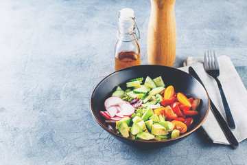 Vegan buddha bowl. Healthy vegetarian salad with cherry tomatoes, cucumber, radish,, avocado and lettuce.