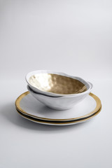 New luxury elegance cutlery view from above on a isolated background. Top view. Porcelain white saucer with soup bowl, golden ring. Trendy plate. Flat lay view.