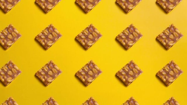 Sweet peanut brittle "pe de moleque" yellow background looping 4k