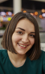 Obraz premium Woman smiling with perfect smile in mall and looking at camera. Image for your stories.