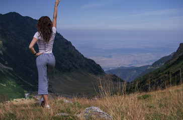 Girl Traveler on mountain summit enjoying aerial view hands raised over clouds. Travel Lifestyle concept adventure happiness freedom emotions. Joyfully. space for text