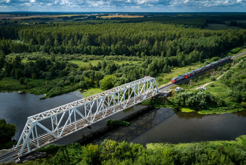 Train rides to the bridge across the river in sunny summer weather