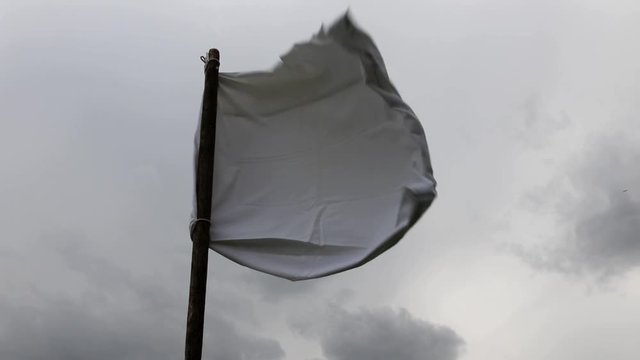 The white flag against the gray sky. Surrender concept.
