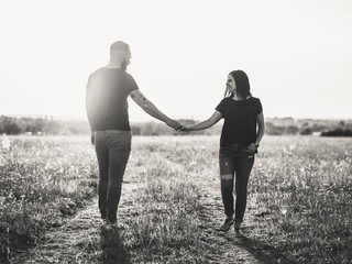 young couple walking in park at sunset