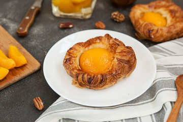 tartlet with apricot, sweet pastries on a black background, pastry shop.