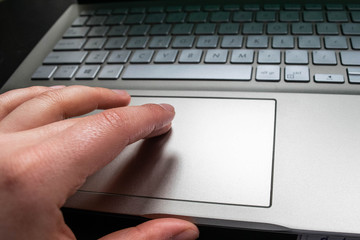 hand on the touchpad on a laptop