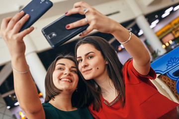 Obraz premium two women met and hugged, they are happy and take selfies