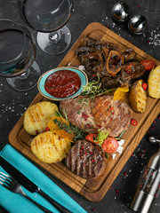 Fototapeta na wymiar Meat grill set with wine on black wooden background