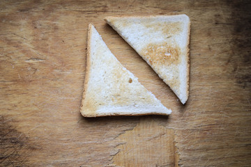 Two pieces of bread on a wooden board