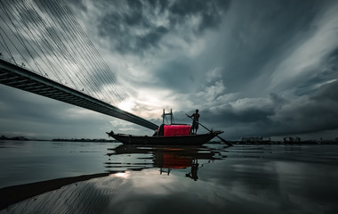 Boat on a river under the monsoon sky in Kolkata