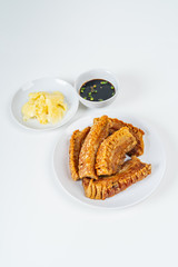 Deep Fried Crispy Streaky Pork Belly Thai and Chinese Food on White Plate with Sauce and Ginger on White Background Isolated.
