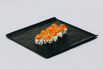Spice roll with tuna on a black plate