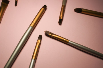 Makeup brushes on a pink background