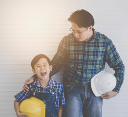 Builder father is Stading next to his son for family connection concept in vintage tone