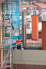trabajadores subiendo piezas a una obra con una polea 