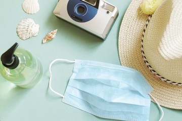 Summer tourism during coronavirus COVID-19 concept. Sun hat, camera, protective face mask,...