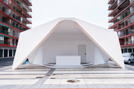White architectural entrance to a car parking close to residential area