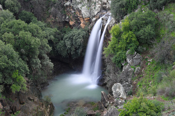 High waterfall and greenery all around. Long exposure photography.