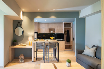 Modern grey and wooden interior of small studio apartment. Front view of hotel flat room witn...