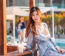 Woman on a beach side bar with drinking milk shake for Summer Vacation concept.
