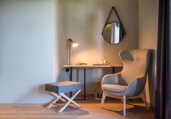 Modern interior of grey room with wingback armchair. Scandinavian style background with empty wall copy space