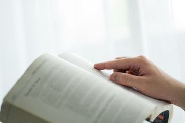 Close up a male hands writing something with pencil on paper in the notebook.
