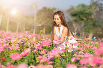 Fototapeta na wymiar happy young woman enjoying summer in zinnia field. Beautiful woman relaxing in pink flower garden.