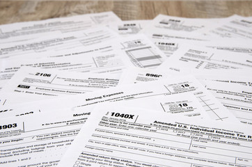 different tax forms 1040 on a wooden table