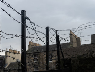 Alambre en la ciudad. Alambrada metálica en el muro de una calle.