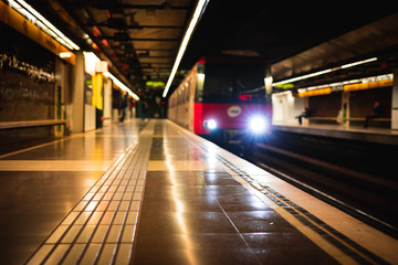 Train arriving at an empty subway train station blurred