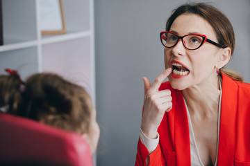 Speech therapist holding letter R and girl back view. Speech therapist teaches the girls to say the...