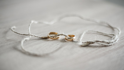 
Wedding rings strung on a thread on a table