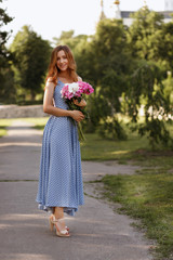 girl walks in the summer in the city in a beautiful sundress. slim figure, romantic image