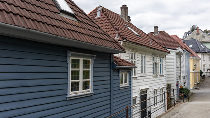 Cozy grey and white wooden old traditional houses with red roofs. Scandinavian architecture streets in Bergen, Norway. Moody cityscape