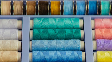 Nähgarnrollen in diversen Farben bei einer Schneiderei vor weißen Hintergrund 