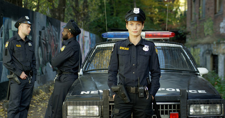 Police officers with his patrol car in the background.