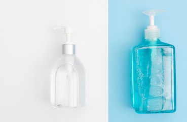 White and blue bottles of sanitizer or liquid soap for hand hygiene to protect from corona virus over two tone background,flat lay