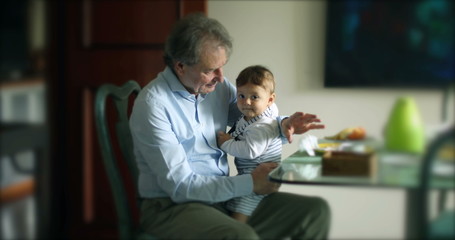 Candid grandfather holding grandson baby casual.