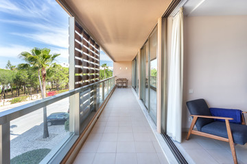 A modern, long corridor located outside the house, hotel, overlooking the street.
