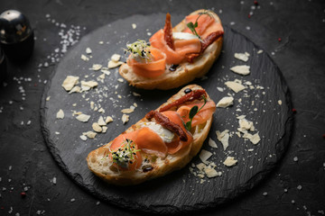 sandwich with salmon on a dark background