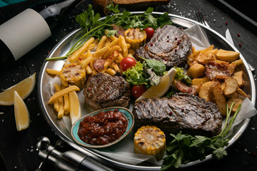 Meat grill set with wine on black wooden background
