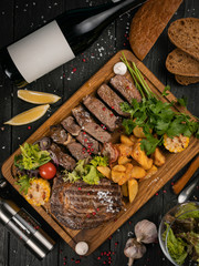 Meat grill set with wine on black wooden background