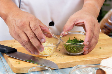 Chef hold cup of chopped parsley and garlic for cook garlic bread