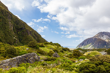 Mountains and green hills in the Southern Alps. A trail between two lakes. South Island, New Zealand