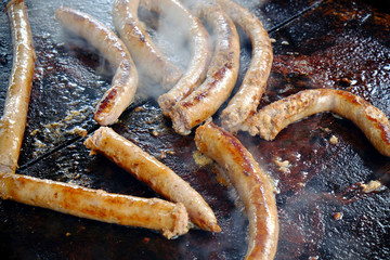 Salsicce di maiale cucinate su una piastra rovente