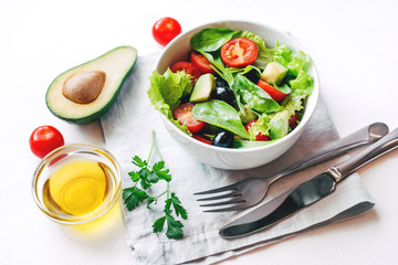 Fresh salad of avocado, cherry, arugula and olives made at home. Vegan food. The concept of healthy eating. Front view.