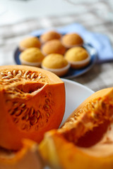 Fresh pumpkin pieces with seeds and pumpkin muffins