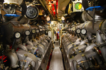 Inside submarine engine room with diesel engine. Military vessel.