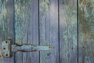 A fragment of an old wooden door with a rusty door hinge. Barn door. The loft-style. Shabby chic